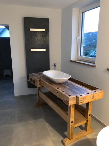 gefliestes Badezimmer mit Waschtisch aus Holz