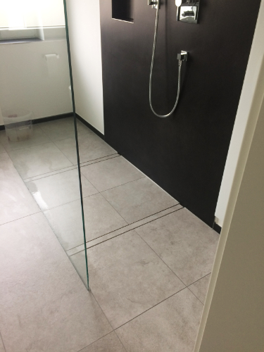 Badezimmer mit gefliestem Boden und Dusche